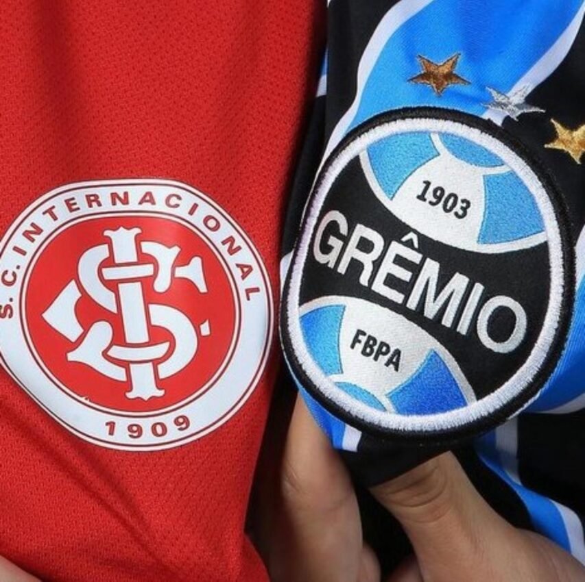 Escudos do Internacional e do Grêmio lado a lado, estampados nas camisas vermelha e tricolor, simbolizando o clássico Gre-Nal.